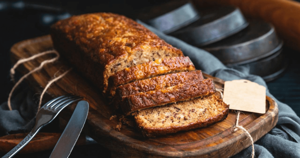 A freshly baked, golden-brown banana bread loaf sliced to reveal its moist, tender texture, highlighting the secrets from Simply Recipes Banana Bread.