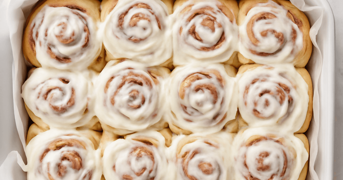 Freshly baked cinnamon rolls topped with creamy frosting, a delicious homemade cinnamon roll recipe.